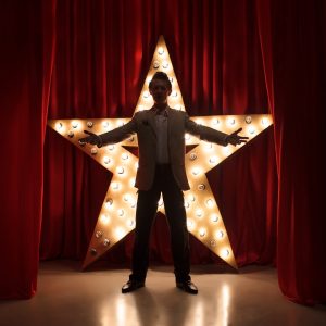 Man on stage with star on background